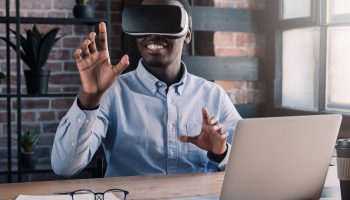Portrait of young african american professional using augmented virtual reality in modern loft office. VR technology